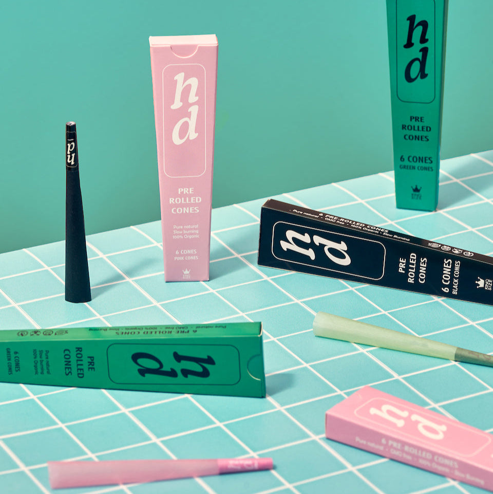 Pre-rolled cone packaging with visible branding on a checkered surface.