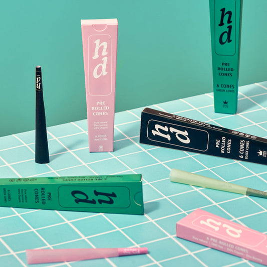 Pre-rolled cone packaging with visible branding on a checkered surface.